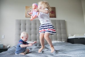 Chicago birth photography - baby and sister jumping on bed